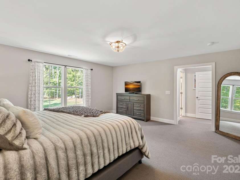 4195 Island Fox Lane, Denver, NC 28037.  MLS# CAR4243299, YatesRealty ID 10051. Spacious primary suite offers peaceful wooded views.