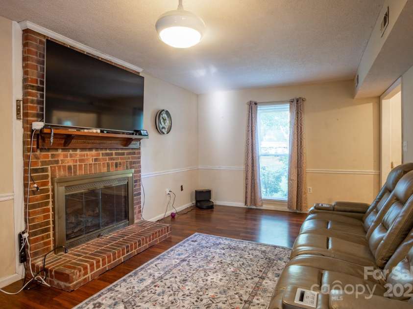 9801 Kent Village Drive, Charlotte, NC 28269.  MLS# CAR4252245, YatesRealty ID 10090. Living room with fireplace