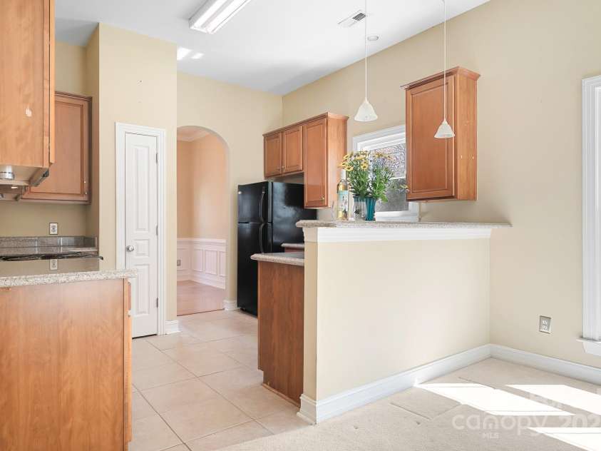 19221 Coachmans Trace, Cornelius, NC 28031.  MLS# CAR4241031, YatesRealty ID 10121. Kitchen with 42inch cabinets, pantry, granite counters and plenty of room to work around in while cooking. Window over sink for natural lighting.