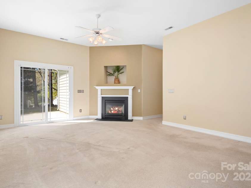 19221 Coachmans Trace, Cornelius, NC 28031.  MLS# CAR4241031, YatesRealty ID 10121. Spacious great room with high ceiling, gas fireplace, sliding doors to patio. Open to the kitchen area and locate near half bath.