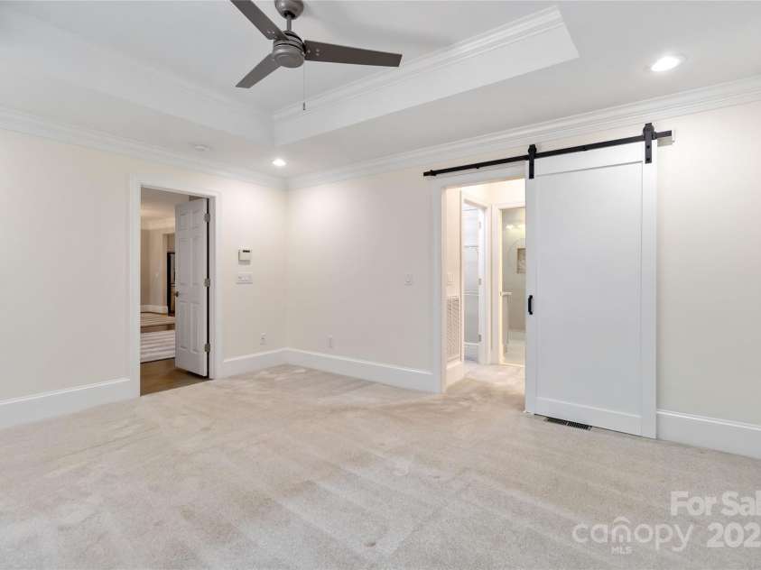 5916 Bridger Court, Charlotte, NC 28211.  MLS# CAR4184678, YatesRealty ID 10123. Primary bedroom on main floor with barn door to beautiful bathroom,  tray ceiling, freshly painted walls