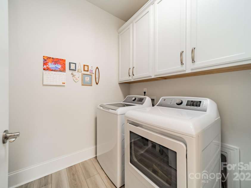 2014 Newstyle Way, Tega Cay, SC 29708.  MLS# CAR4190595, YatesRealty ID 10124. Laundry Room with Cabinets, Laundry sink (behind door) and Washer and Dryer that convey
