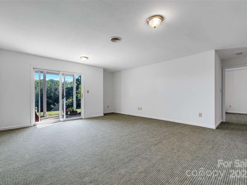 77 Chestnut Street, Tryon, NC 28782.  MLS# CAR4307733, YatesRealty ID 1015. Large open downstairs room with walkout doors for convenience and natural light.