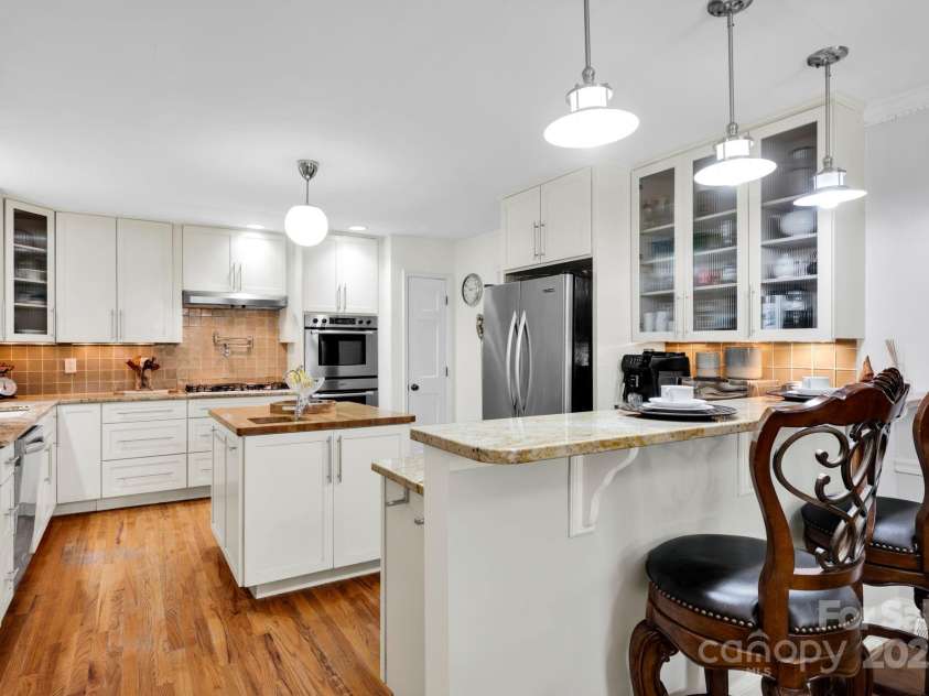 4937 Broken Saddle Lane, Charlotte, NC 28226.  MLS# CAR4244000, YatesRealty ID 10175. Kitchen with breakfast bar and island with prep sink.