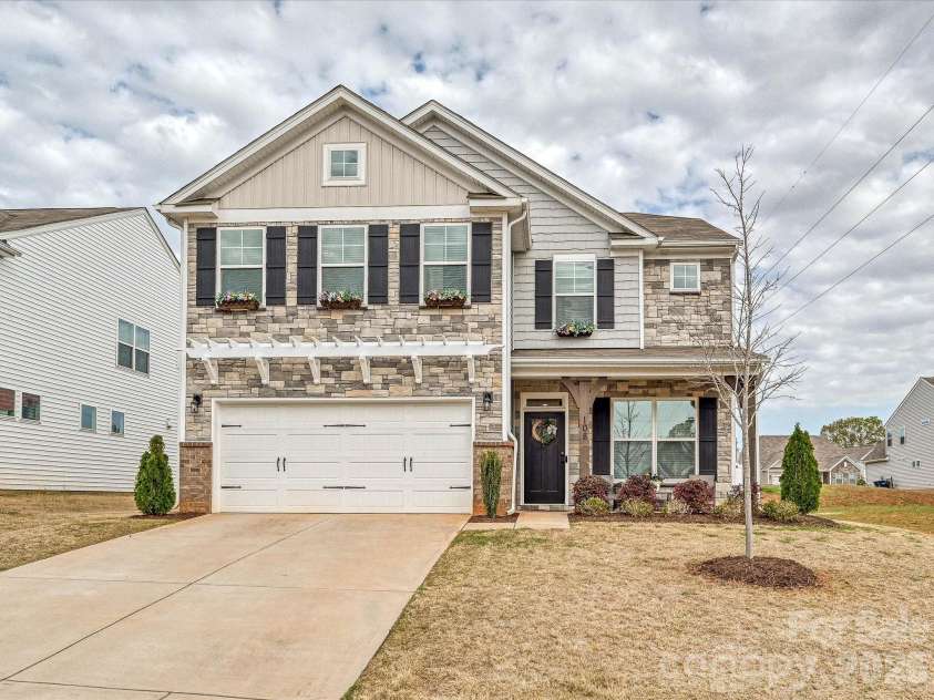 108 Old Field Road, Statesville, NC 28677.  MLS# CAR4360995, YatesRealty ID 10252. Beautiful two-story home featuring a charming stone façade, covered front porch, and spacious two-car garage, offering inviting curb appeal in a desirable community setting.
