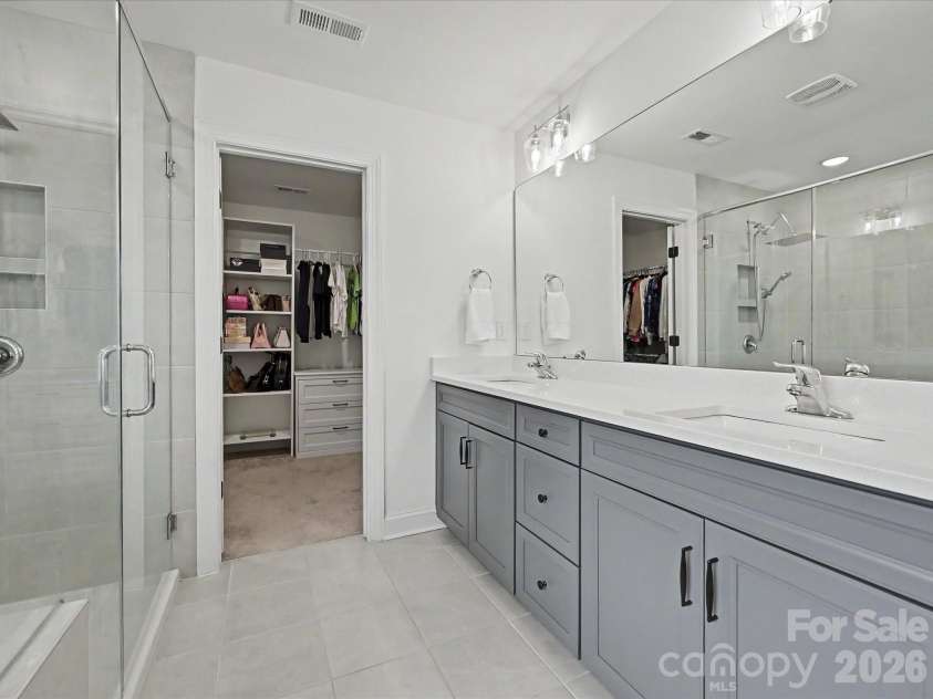 108 Old Field Road, Statesville, NC 28677.  MLS# CAR4360995, YatesRealty ID 10252. Spa-like primary bathroom featuring dual vanities, a spacious glass-enclosed shower, and a large walk-in closet for ultimate comfort and convenience.