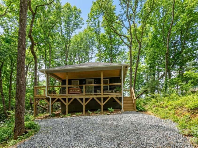 137 Arbutus Trail, Hendersonville, NC 28792.  MLS# CAR4360777, YatesRealty ID 10264. AI created image of trees 