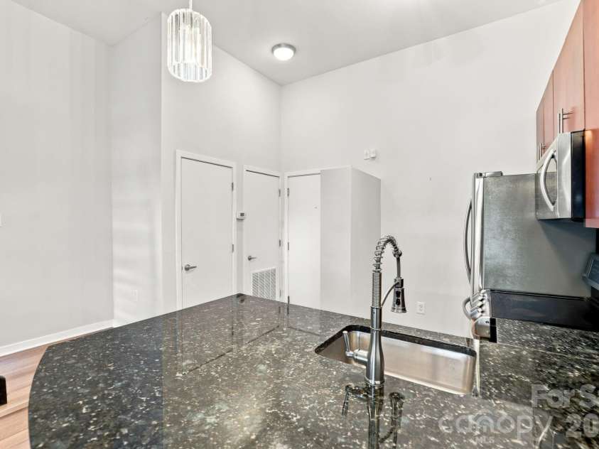 2125 Southend Drive, Charlotte, NC 28203.  MLS# CAR4415556, YatesRealty ID 10291. Generous granite countertop space and breakfast bar make the kitchen functional for both cooking and entertaining.