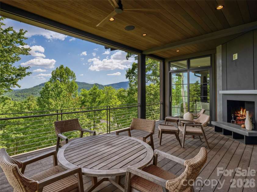 1121 Timberbluff Way, Arden, NC 28704.  MLS# CAR4389216, YatesRealty ID 10325. Covered porch featuring a stone fireplace for year-round enjoyment