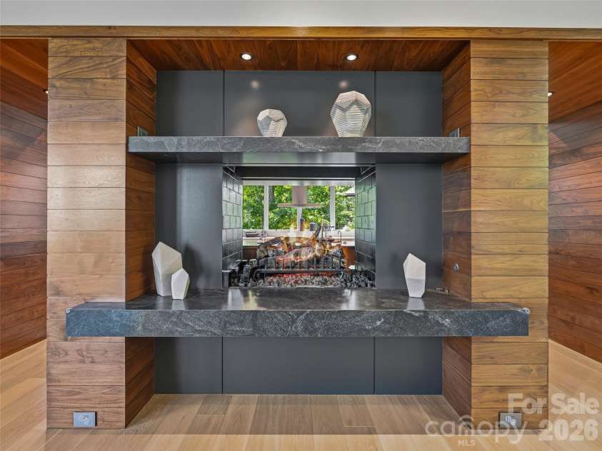 1121 Timberbluff Way, Arden, NC 28704.  MLS# CAR4389216, YatesRealty ID 10325. Dramatic see-through fireplace connecting gathering spaces