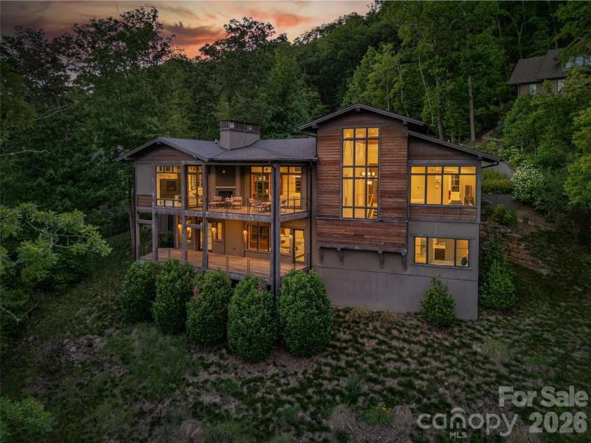 1121 Timberbluff Way, Arden, NC 28704.  MLS# CAR4389216, YatesRealty ID 10325. Evening illumination highlights the home's warm contemporary character