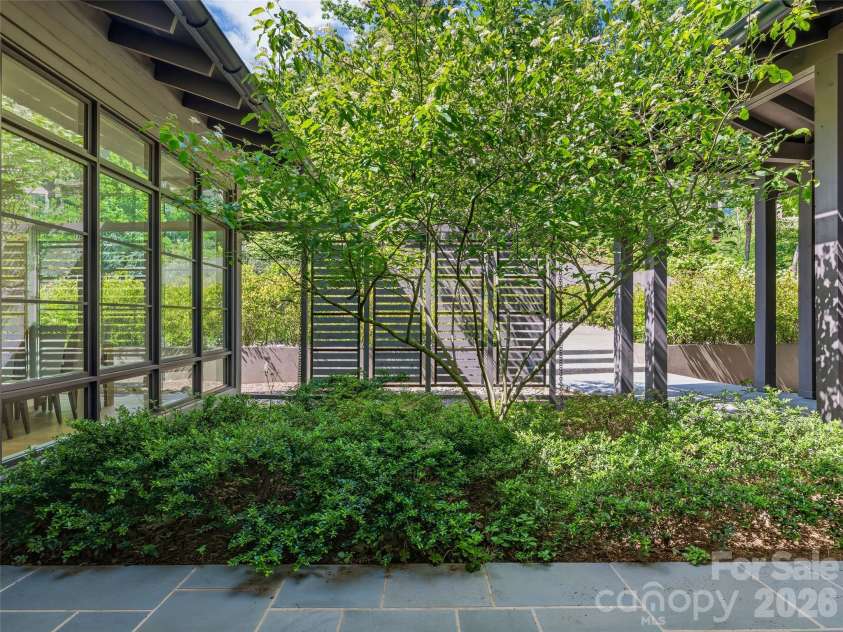 1121 Timberbluff Way, Arden, NC 28704.  MLS# CAR4389216, YatesRealty ID 10325. Private entry courtyard offering a quiet outdoor retreat