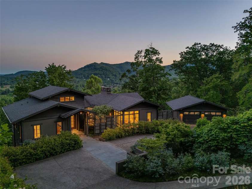1121 Timberbluff Way, Arden, NC 28704.  MLS# CAR4389216, YatesRealty ID 10325. Twilight aerial showcasing privacy, architecture, and long-range views