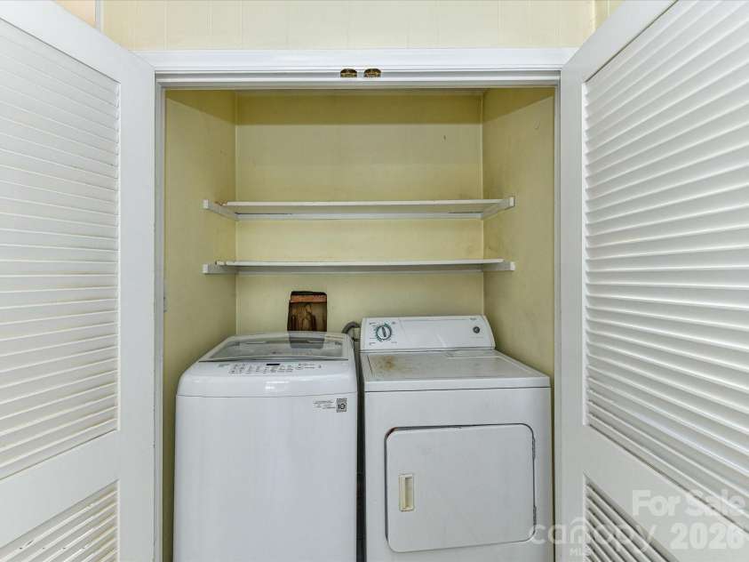 556 Eastway Street, Davidson, NC 28036.  MLS# CAR4365491, YatesRealty ID 10328. Convenient laundry area with washer and dryer and additional shelving for storage.