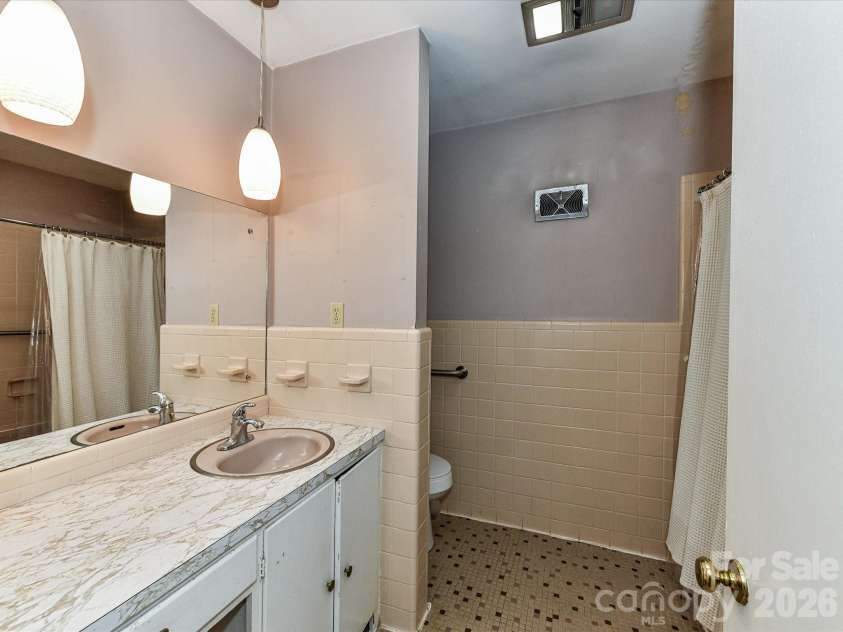 556 Eastway Street, Davidson, NC 28036.  MLS# CAR4365491, YatesRealty ID 10328. Full bathroom with tiled shower, single vanity, and functional layout.