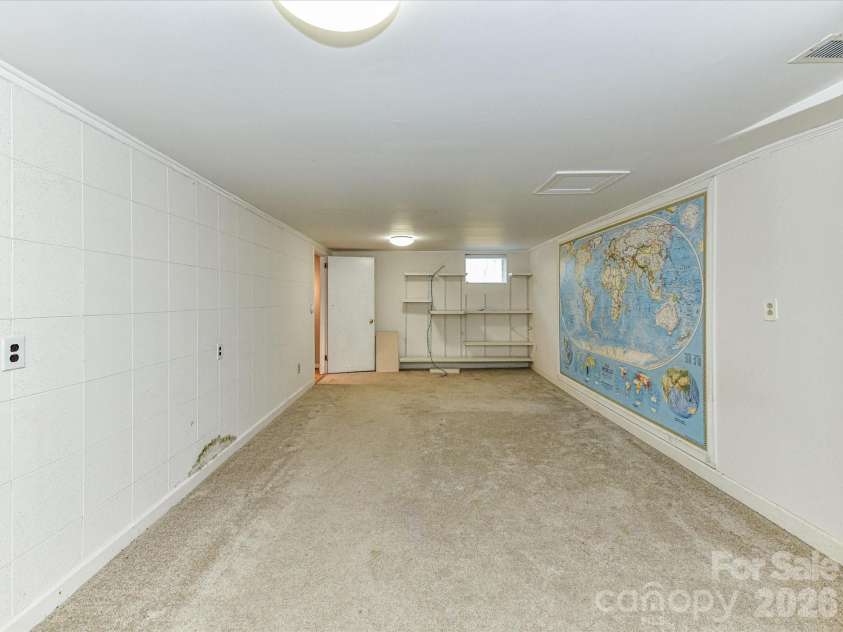 556 Eastway Street, Davidson, NC 28036.  MLS# CAR4365491, YatesRealty ID 10328. Versatile lower-level flex space with built-in shelving, ideal for a media room, home office, or recreation area.