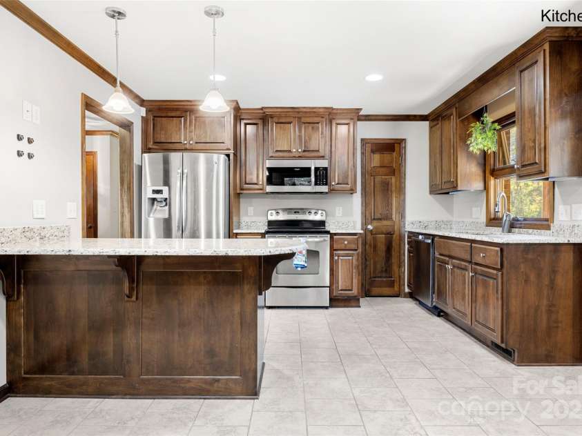 5303 Rogers Road, Monroe, NC 28110.  MLS# CAR4312504, YatesRealty ID 1046. Custom kitchen with handmade cabinetry, stainless appliances and granite counter tops