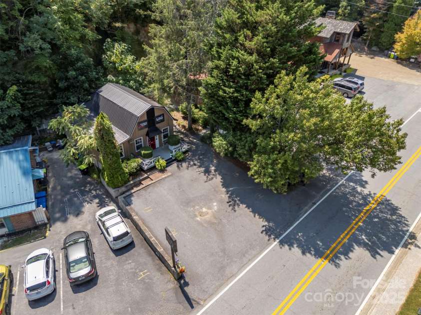 172 formerly 153 Main Street, Saluda, NC 28773.  MLS# CAR4225037, YatesRealty ID 1048. Wildflour Bakery, Mewdlics (Wine and gifts), The Gardener's Cottage (gift shop) are to the left in the Nostalgia Courtyard. To the right is Don Mintz Builders, Edward Jones, and Spring Creek Interiors.