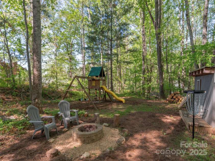 35 Mann Drive, Asheville, NC 28805.  MLS# CAR4252485, YatesRealty ID 10548. Rear side portion of lot with fire pit to enjoy, play set and storage/play building;