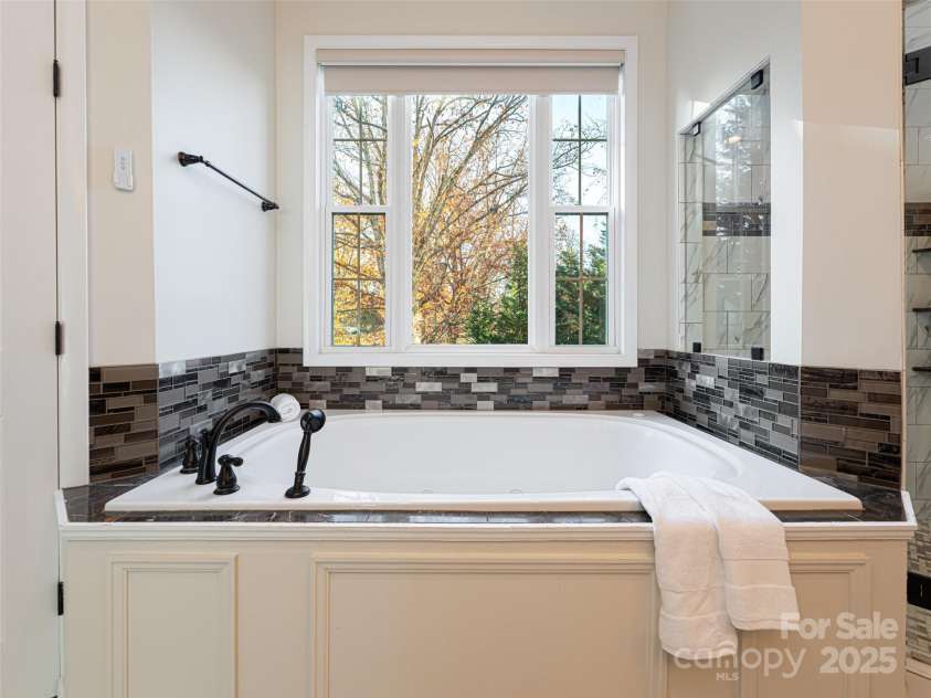 70 Wyatt Street, Asheville, NC 28803.  MLS# CAR4322963, YatesRealty ID 10553. Upstairs Primary Bathroom Suite with large window overlooking nature while allowing complete privacy