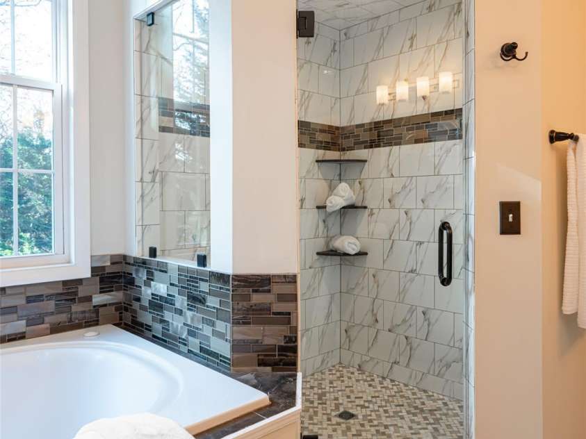 70 Wyatt Street, Asheville, NC 28803.  MLS# CAR4322963, YatesRealty ID 10553. Walk-In shower with glass window overlooking nature in upstairs Primary Bath