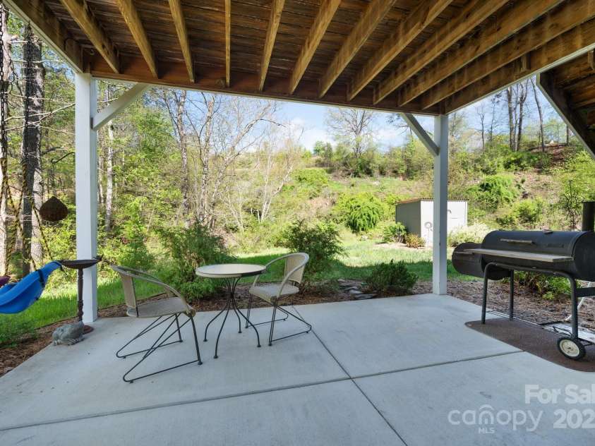 85 Laurel Cove Road, Candler, NC 28715.  MLS# CAR4251695, YatesRealty ID 10564. Covered Main Level Back Patio Overlooks the Creek
