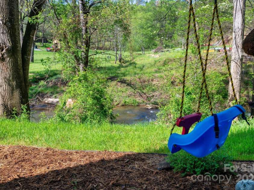 85 Laurel Cove Road, Candler, NC 28715.  MLS# CAR4251695, YatesRealty ID 10564. Rushing Creek Surrounds this Beautiful Property on Three Sides