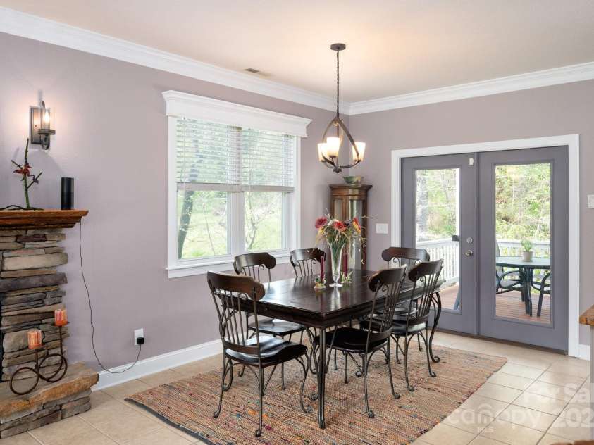85 Laurel Cove Road, Candler, NC 28715.  MLS# CAR4251695, YatesRealty ID 10564. Spacious Primary Dining Area Leads to Covered Deck