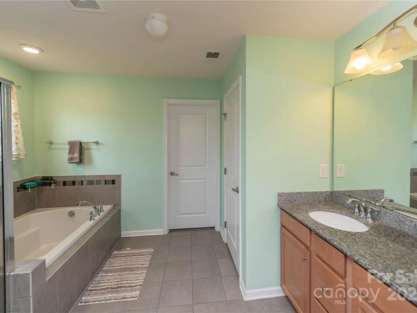 7412 Greene Mill Avenue, Concord, NC 28025.  MLS# CAR4249641, YatesRealty ID 10718. Large bathroom off of the primary bedroom with dual vanities, soaking tub, and walk-in shower
