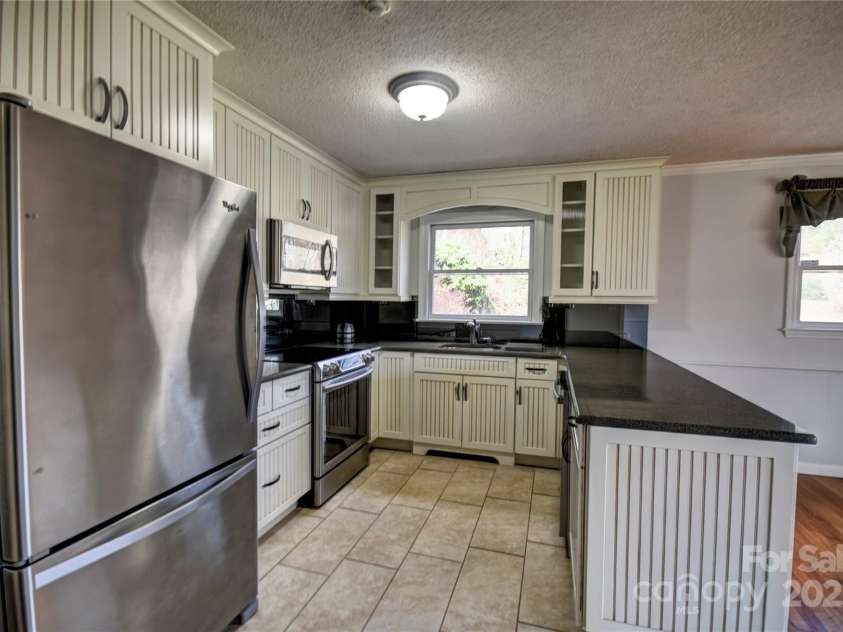 857 Country Club Drive, Maggie Valley, NC 28751.  MLS# CAR4240227, YatesRealty ID 10826. Impressive Kitchen with upgraded cabinets, SS appliances, and solid surface countertops