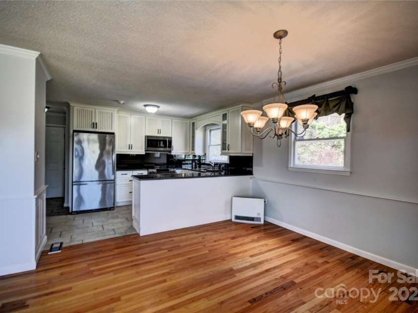 857 Country Club Drive, Maggie Valley, NC 28751.  MLS# CAR4240227, YatesRealty ID 10826. Kitchen from the dining area also a propane heater by the breakfast bar