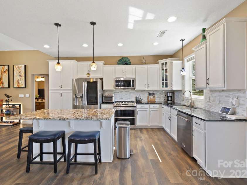 16 Enchanted Oak Lane, Alexander, NC 28701.  MLS# CAR4285091, YatesRealty ID 10833. Kitchen features island w/barstools/open plan