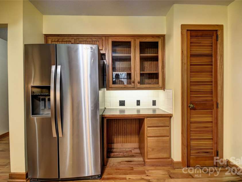 119 Pleasant Hill Circle, Waynesville, NC 28786.  MLS# CAR4325217, YatesRealty ID 1091. Refrigerator and desk with display cabinet overhear- Louvered door is a pantry