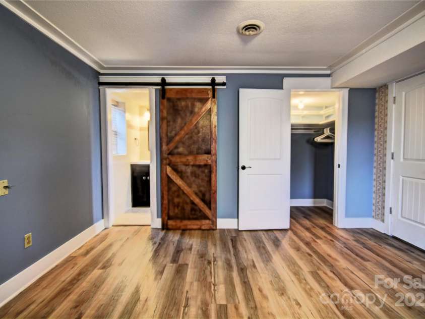 119 Pleasant Hill Circle, Waynesville, NC 28786.  MLS# CAR4325217, YatesRealty ID 1091. Sliding Barn Door to the lower-level primary bathroom and a walk-in closet to the right