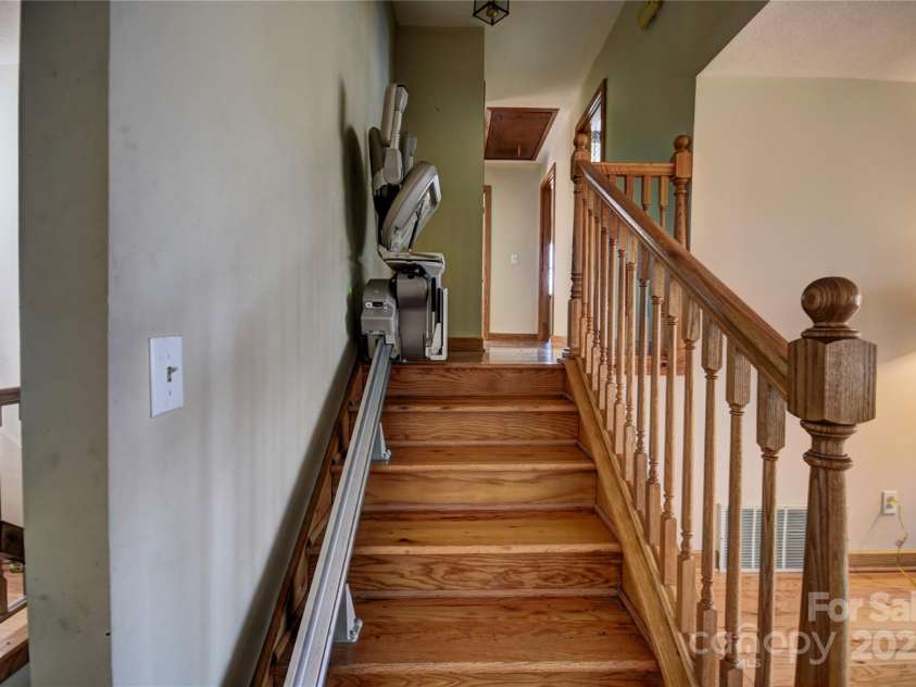 119 Pleasant Hill Circle, Waynesville, NC 28786.  MLS# CAR4325217, YatesRealty ID 1091. Stairs from the main level to the upper bedroom level- note the installed stair lift