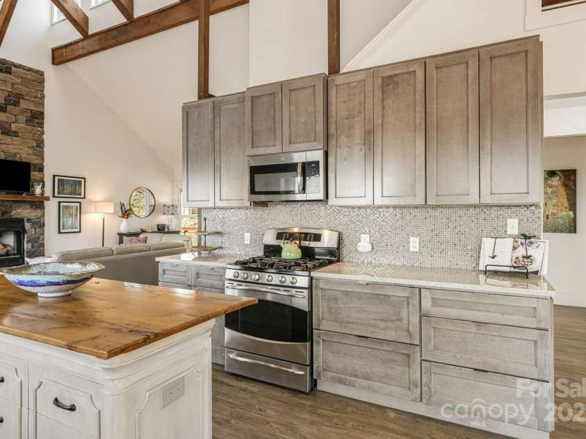 129 Finney Lane, Mars Hill, NC 28754.  MLS# CAR4243744, YatesRealty ID 10915. Gas stove, modern cabinets, granite countertops, and tile backsplash.
