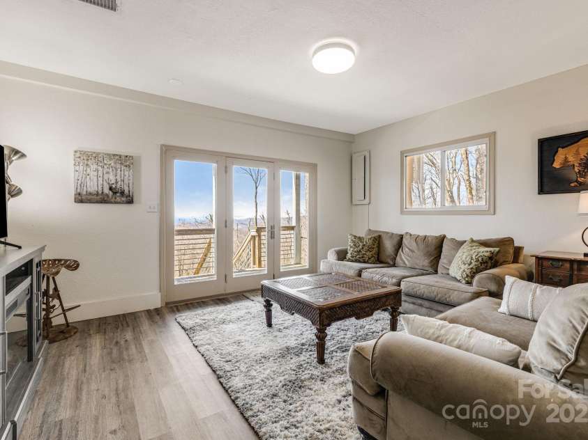 129 Finney Lane, Mars Hill, NC 28754.  MLS# CAR4243744, YatesRealty ID 10915. Lower level living room with doors leading to the fened in yard.