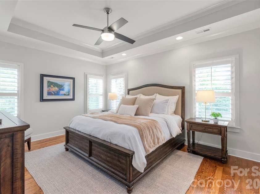 3437 Draper Avenue, Charlotte, NC 28205.  MLS# CAR4364902, YatesRealty ID 10915. The primary suite facing the backyard defines luxury with its architectural tray ceiling, timeless plantation shutters, and pristine hardwoods. Your private sanctuary awaits.