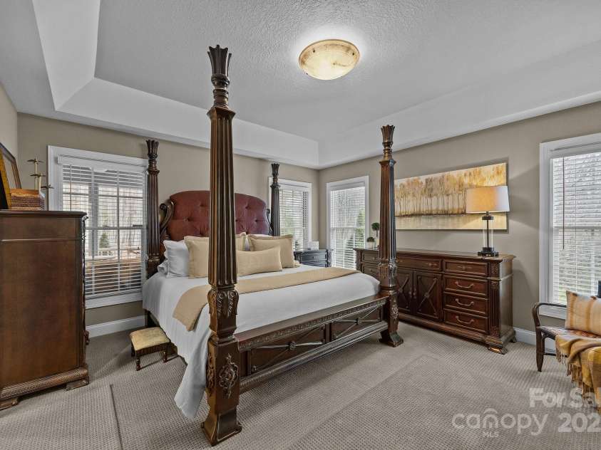 43 Smokemont Drive, Arden, NC 28704.  MLS# CAR4197497, YatesRealty ID 10921. Main level primary bedroom with neutral carpets, trey ceiling and lots of natural light.