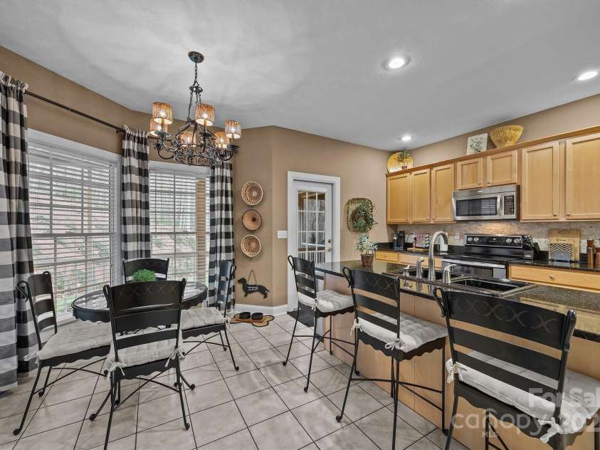 43 Smokemont Drive, Arden, NC 28704.  MLS# CAR4197497, YatesRealty ID 10921. Separate kitchen with maple cabinets, granite countertops and a kitchen dining space.