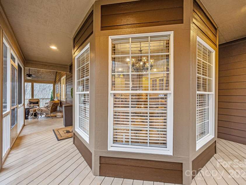 43 Smokemont Drive, Arden, NC 28704.  MLS# CAR4197497, YatesRealty ID 10921. The screen porch slightly wraps around the side of the house.  Inside of the bay window is the kitchen dining area.