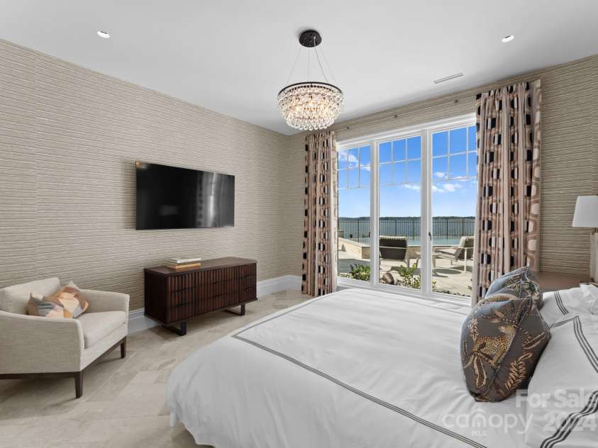 19125 Peninsula Point Drive, Cornelius, NC 28031.  MLS# CAR4180906, YatesRealty ID 1093. This inviting lake-level bedroom overlooks both the pool and lake for unending water views. It is equipped with a private en-suite.