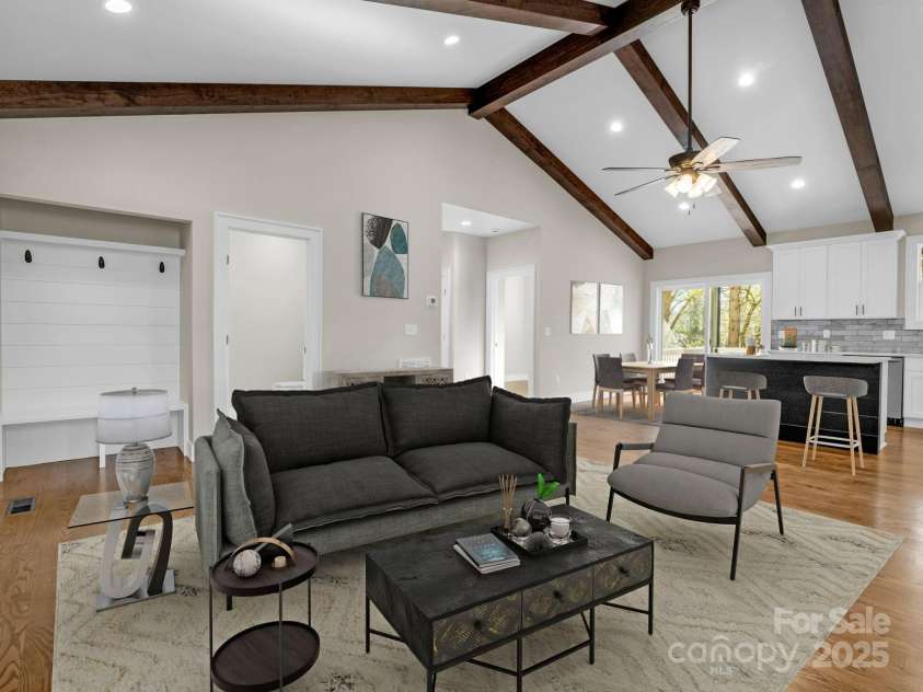 1104 Sylvan Boulevard, Hendersonville, NC 28791.  MLS# CAR4215547, YatesRealty ID 10973. Living area boasts vaulted ceilings and wood beam accents, notice mud room wall near entry way.*Virtually staged