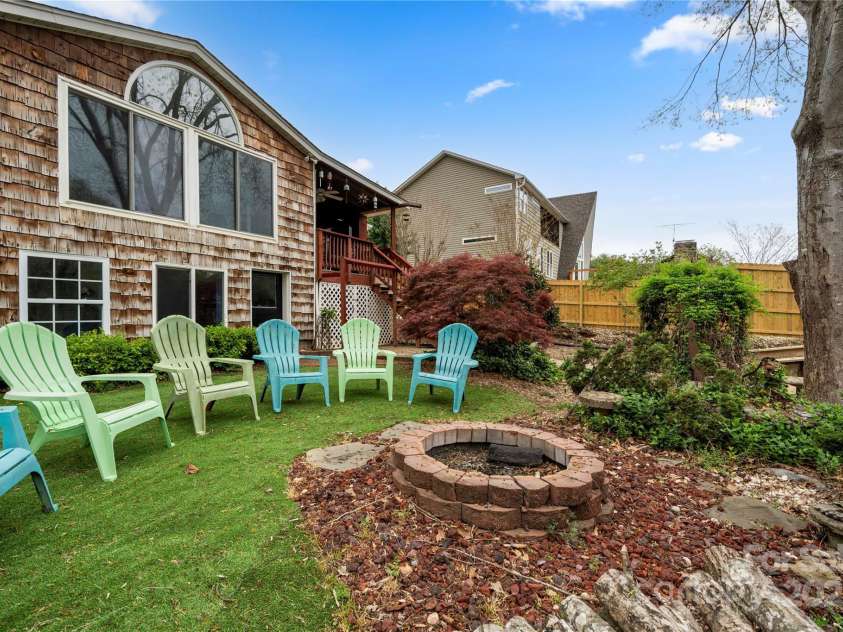 513 Paradise Circle, Belmont, NC 28012.  MLS# CAR4219509, YatesRealty ID 11053. Rear yard with fire pit - large windows overlooking the lake.