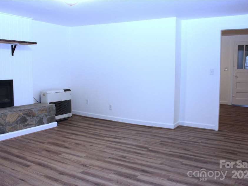 4 Morgan Cove Road, Candler, NC 28715.  MLS# CAR3898041, YatesRealty ID 11057. Living room with new electric fireplace and hearth.