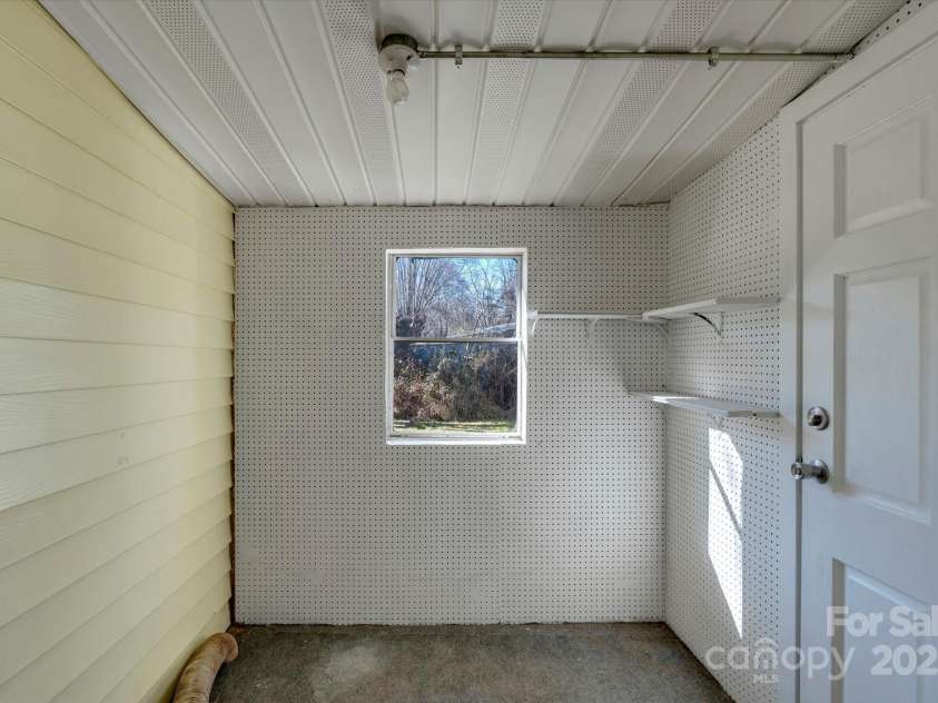 4 Morgan Cove Road, Candler, NC 28715.  MLS# CAR3898041, YatesRealty ID 11057. Mudroom with laundry hookups off the rear porch (ceiling height under 7')