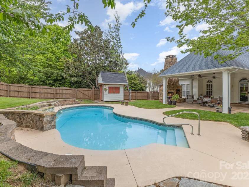 212 Horn Tassel Court, Indian Trail, NC 28079.  MLS# CAR4244678, YatesRealty ID 11066. This property features a fantastic backyard with pool, stone waterfall, building to store all your floats, covered patio, and stone fireplace.