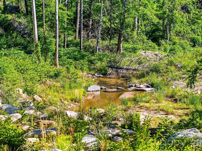 45 Alan Retreat Road, Hendersonville, NC 28792.  MLS# CAR4364735, YatesRealty ID 11110. Listen to the sounds of the bold creek behind the home!