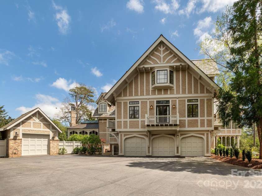 8 Fairway Place, Asheville, NC 28803.  MLS# CAR4245541, YatesRealty ID 11110. A circular driveway leads to both attached and detached garages, providing ample parking.