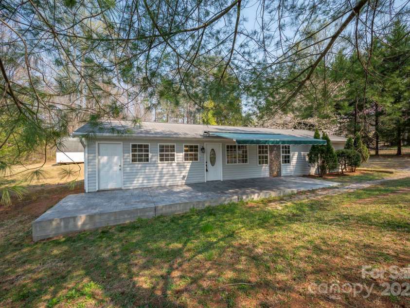 163 Woodland Drive, Columbus, NC 28722.  MLS# CAR4240701, YatesRealty ID 11111. Generous front patio.  Door on the left leads directly to the kitchen.  The center door leads to the living/dining room